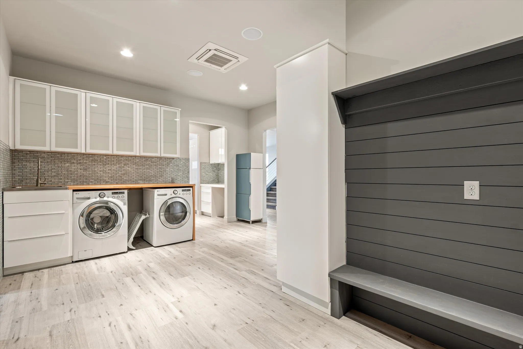 Laundry area featuring cooling unit, washer and dryer, light wood-style floors, and recessed lighting