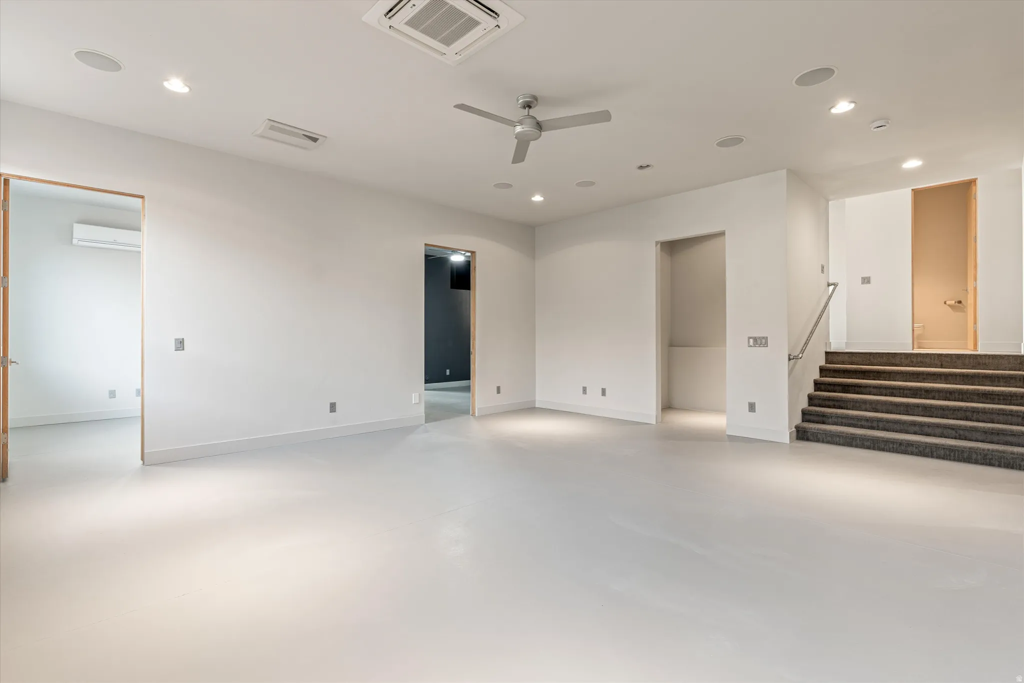 Unfurnished room with finished concrete floors, cooling unit, ceiling fan, and recessed lighting
