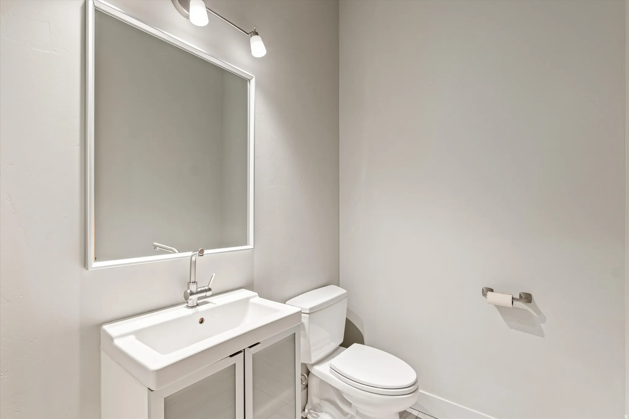 Half bathroom with vanity and toilet