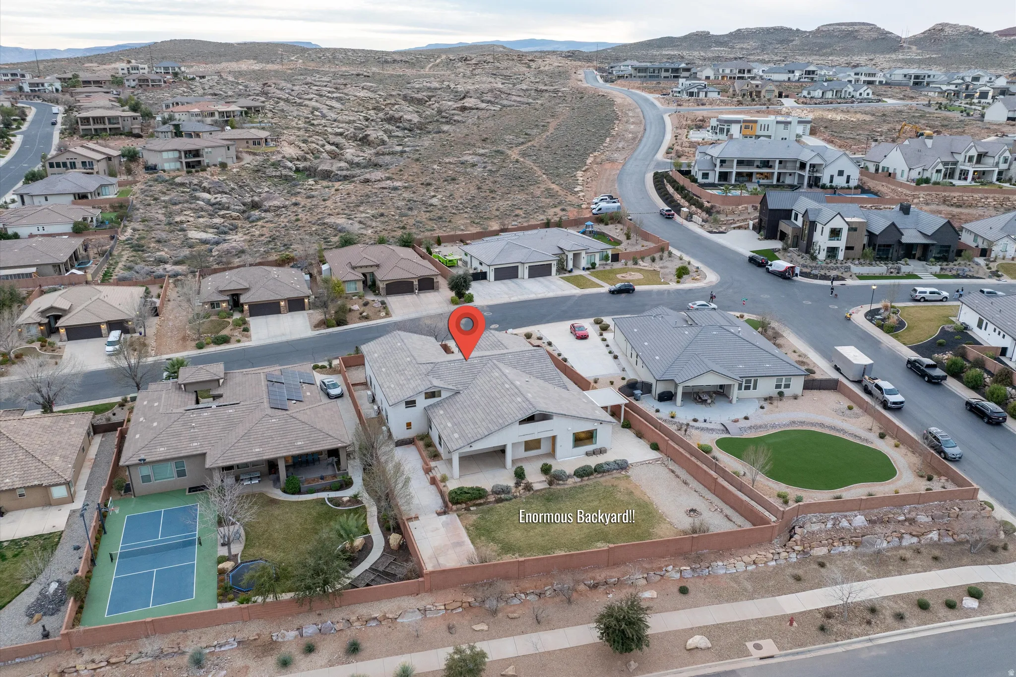 Aerial view of property and surrounding area featuring a mountain backdrop and nearby suburban area
