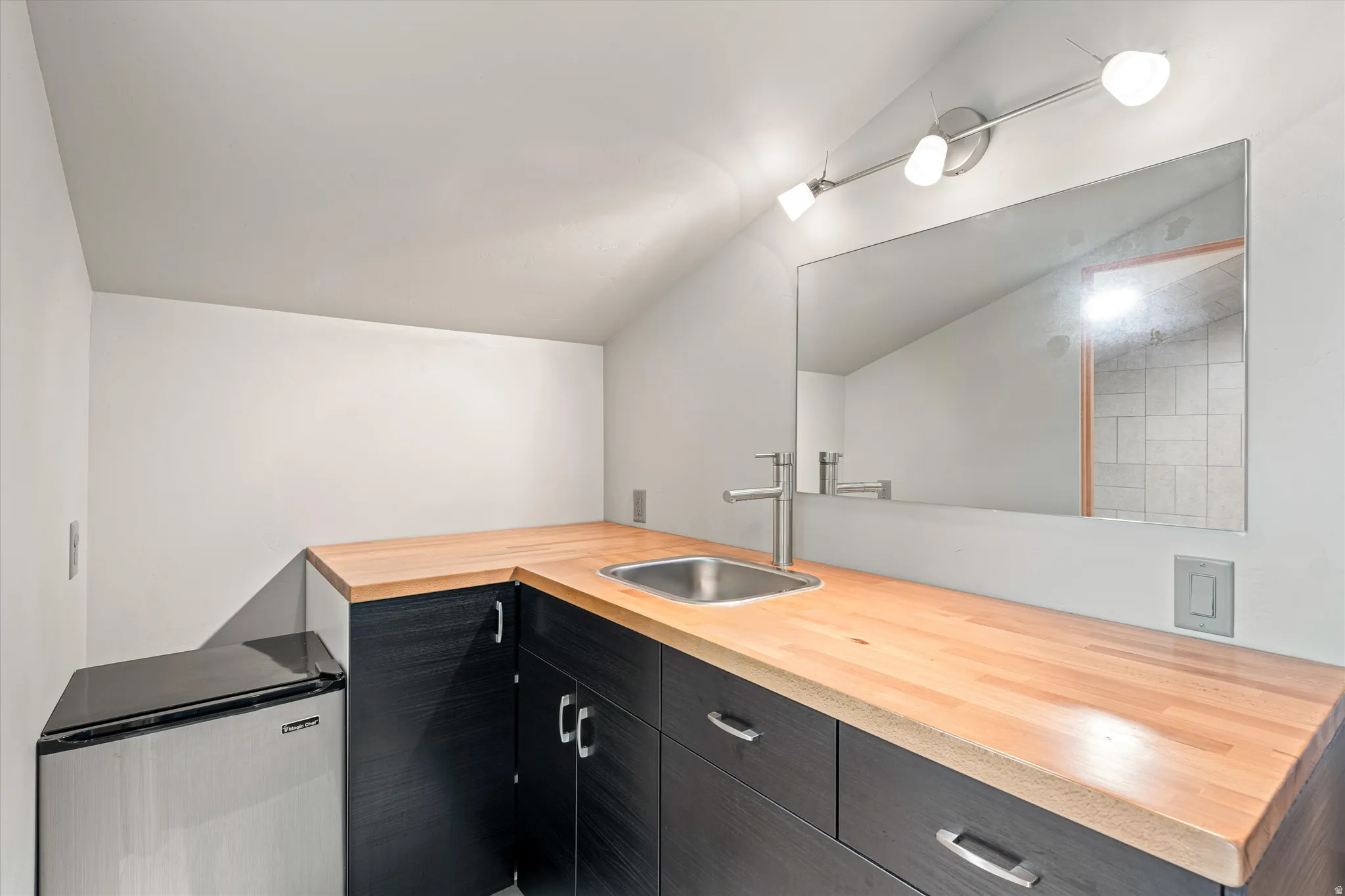 Bathroom featuring vanity and vaulted ceiling