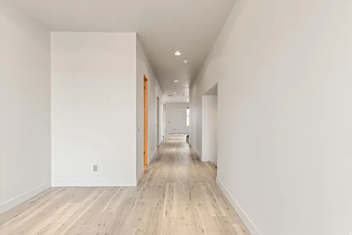 Corridor featuring light wood-type flooring and recessed lighting
