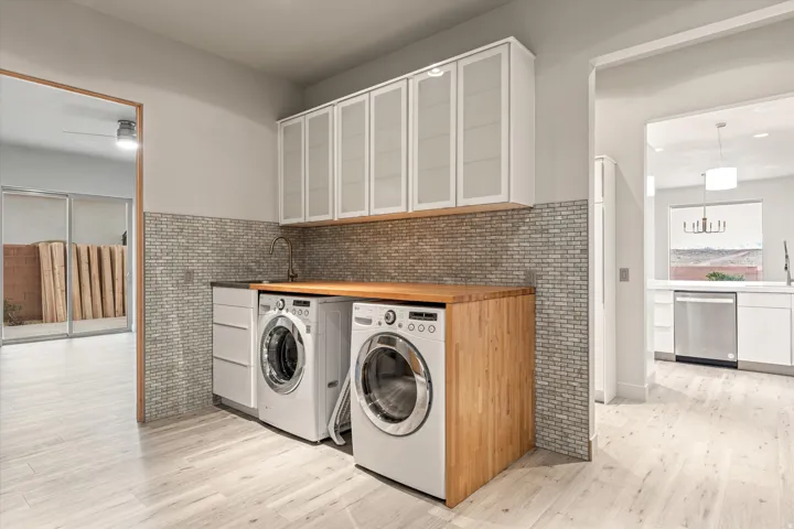 Laundry area with light wood finished floors and washer and clothes dryer