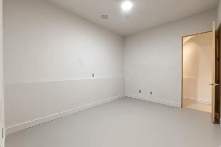 Empty room featuring concrete flooring and baseboards