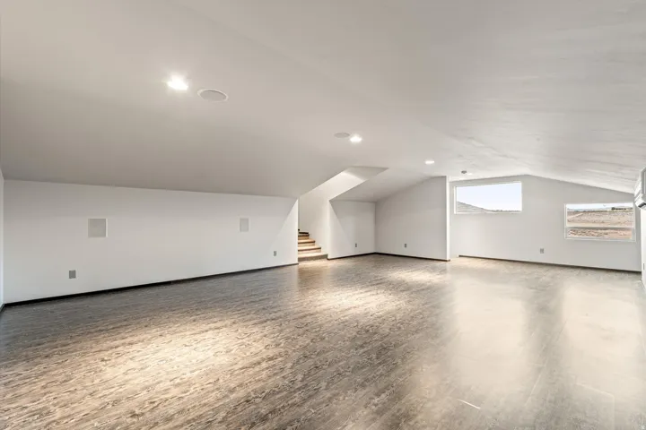 Additional living space with vaulted ceiling and wood finished floors