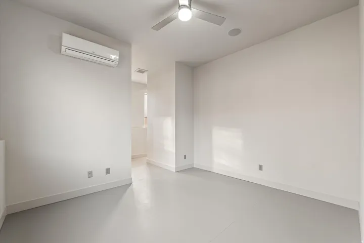 Empty room with concrete floors and ceiling fan