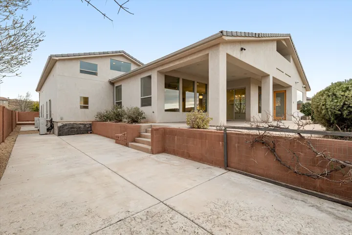 Back of house with a patio area and stucco siding