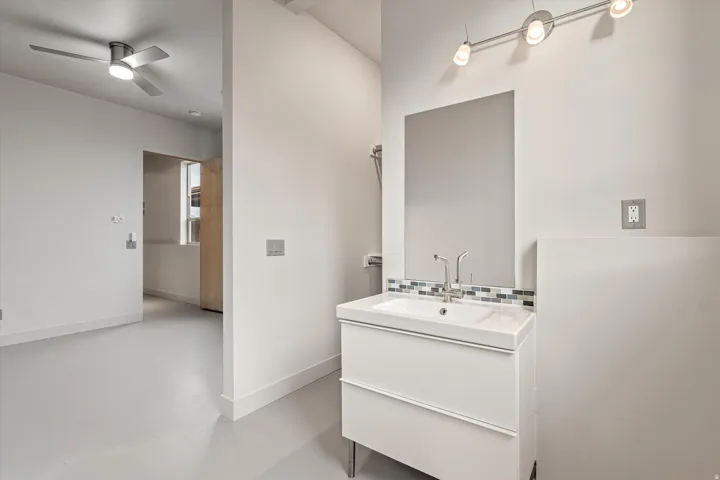 Half bath with vanity, finished concrete floors, and ceiling fan