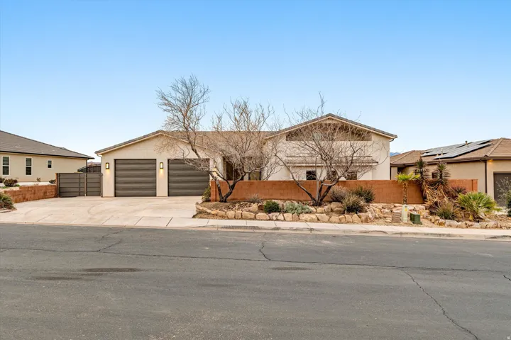 View of front of house featuring a fenced front yard, concrete driveway, a garage, and stucco siding