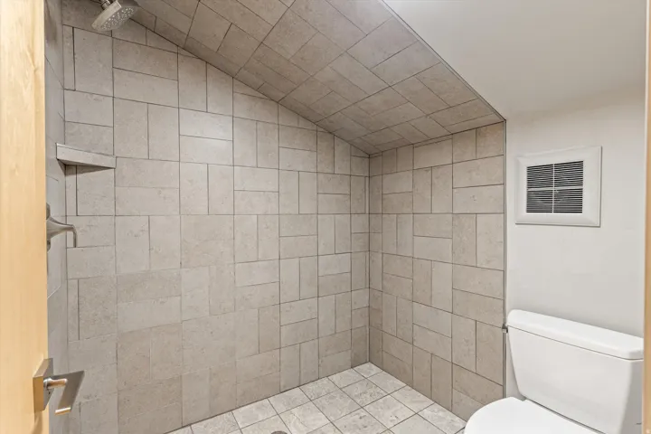 Bathroom with a tile shower and toilet