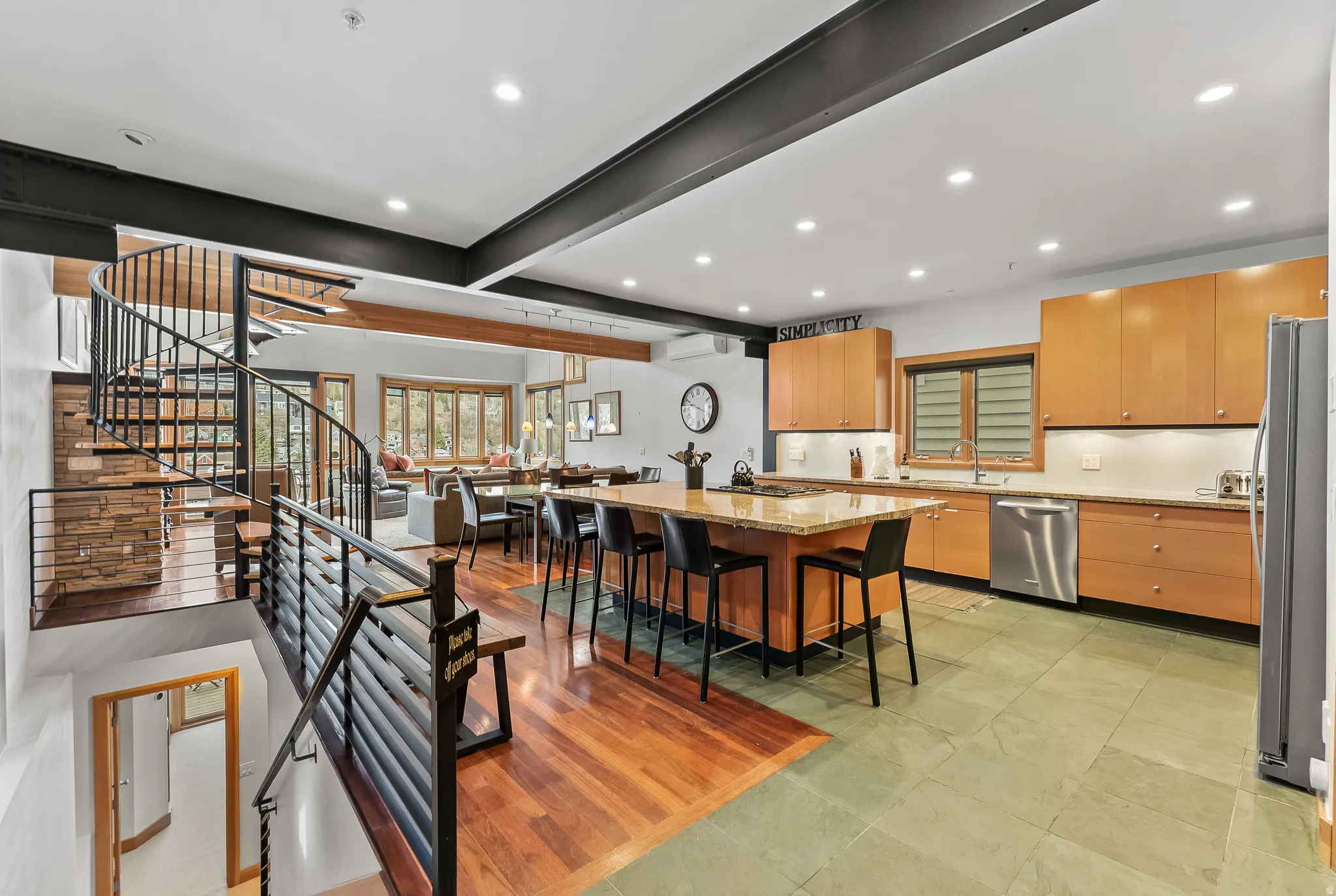 Kitchen with light stone countertops, recessed lighting, a breakfast bar, a kitchen island with sink, and stainless steel appliances