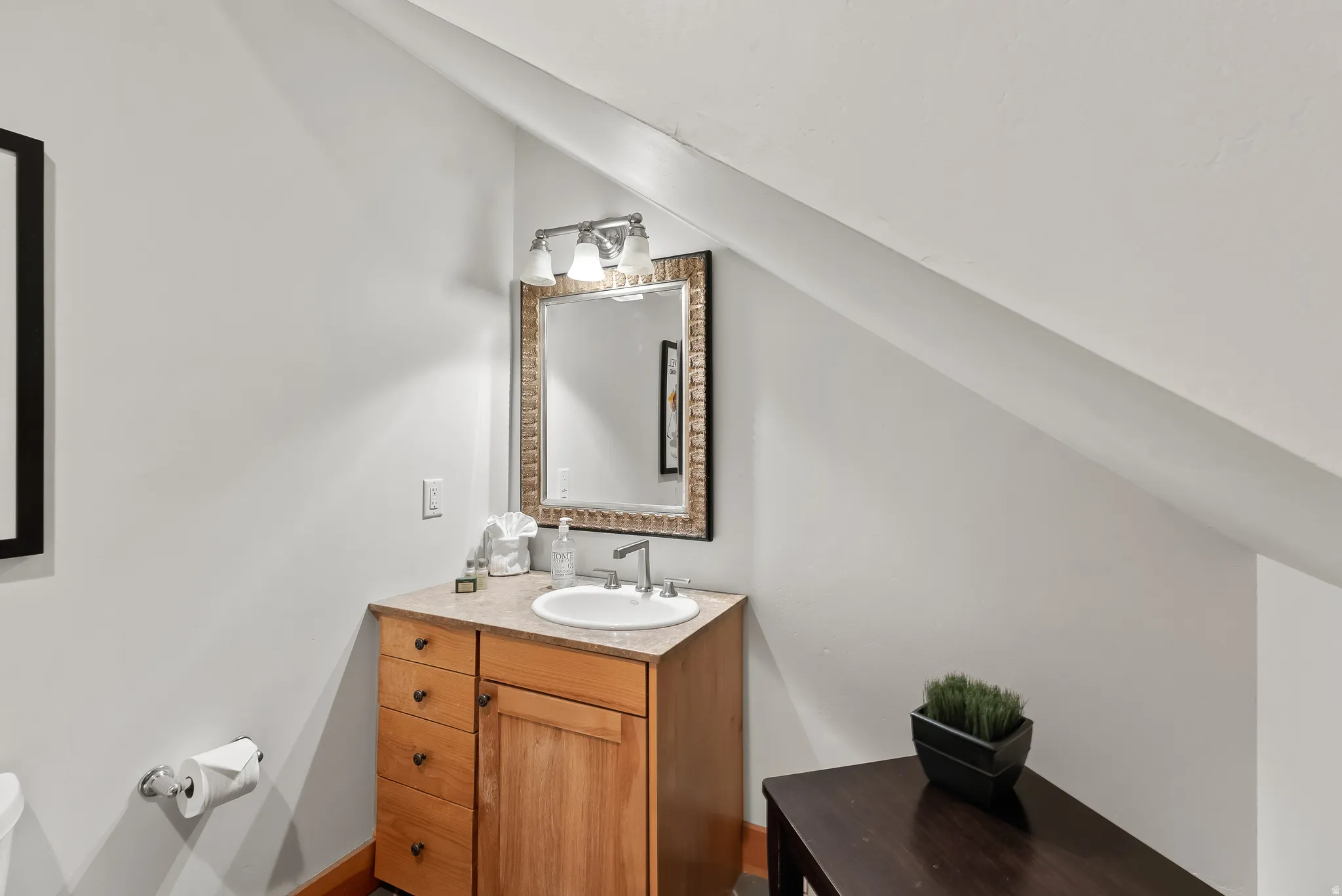 Half bath featuring vanity and lofted ceiling