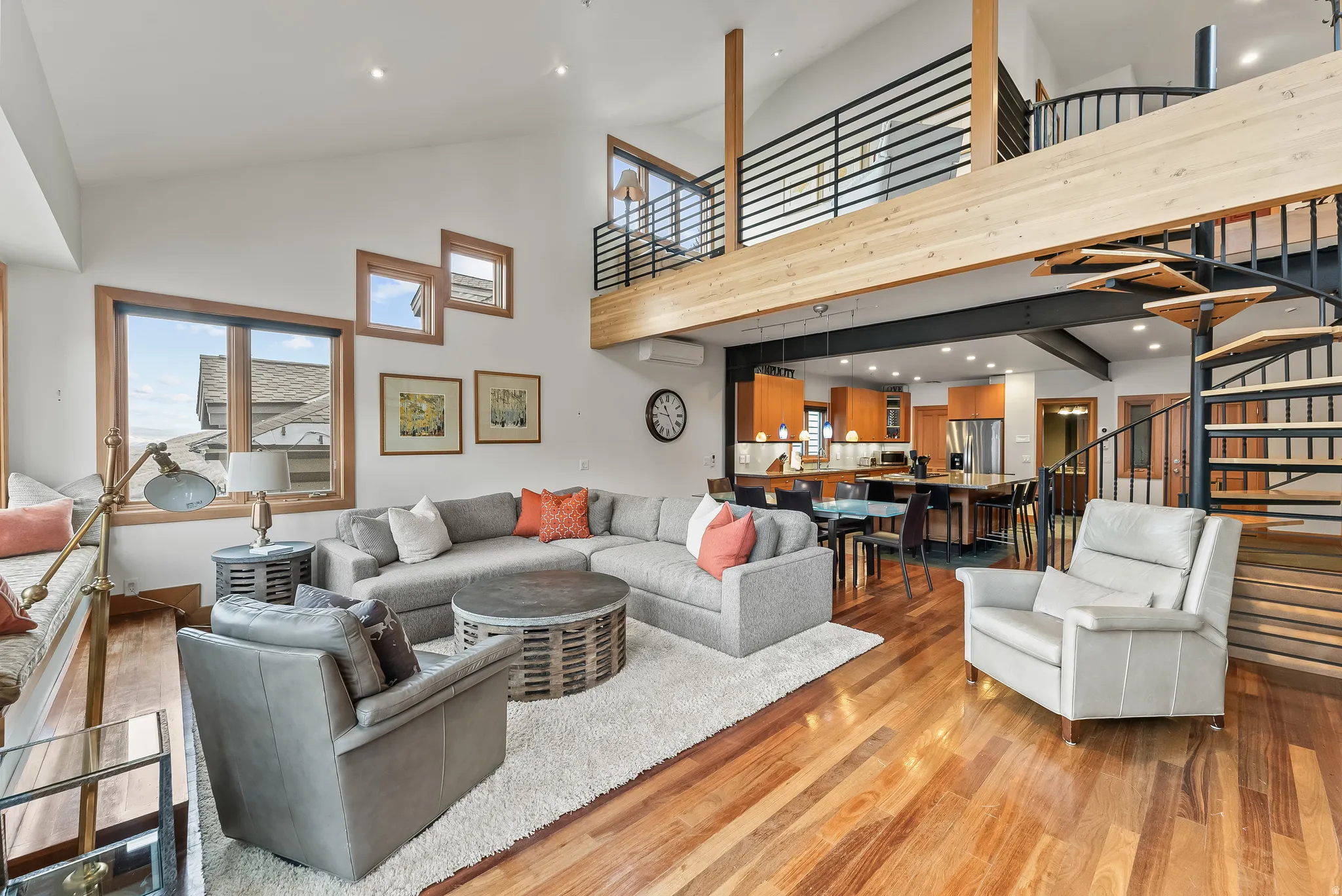 Living area with wood finished floors, a high ceiling, and recessed lighting