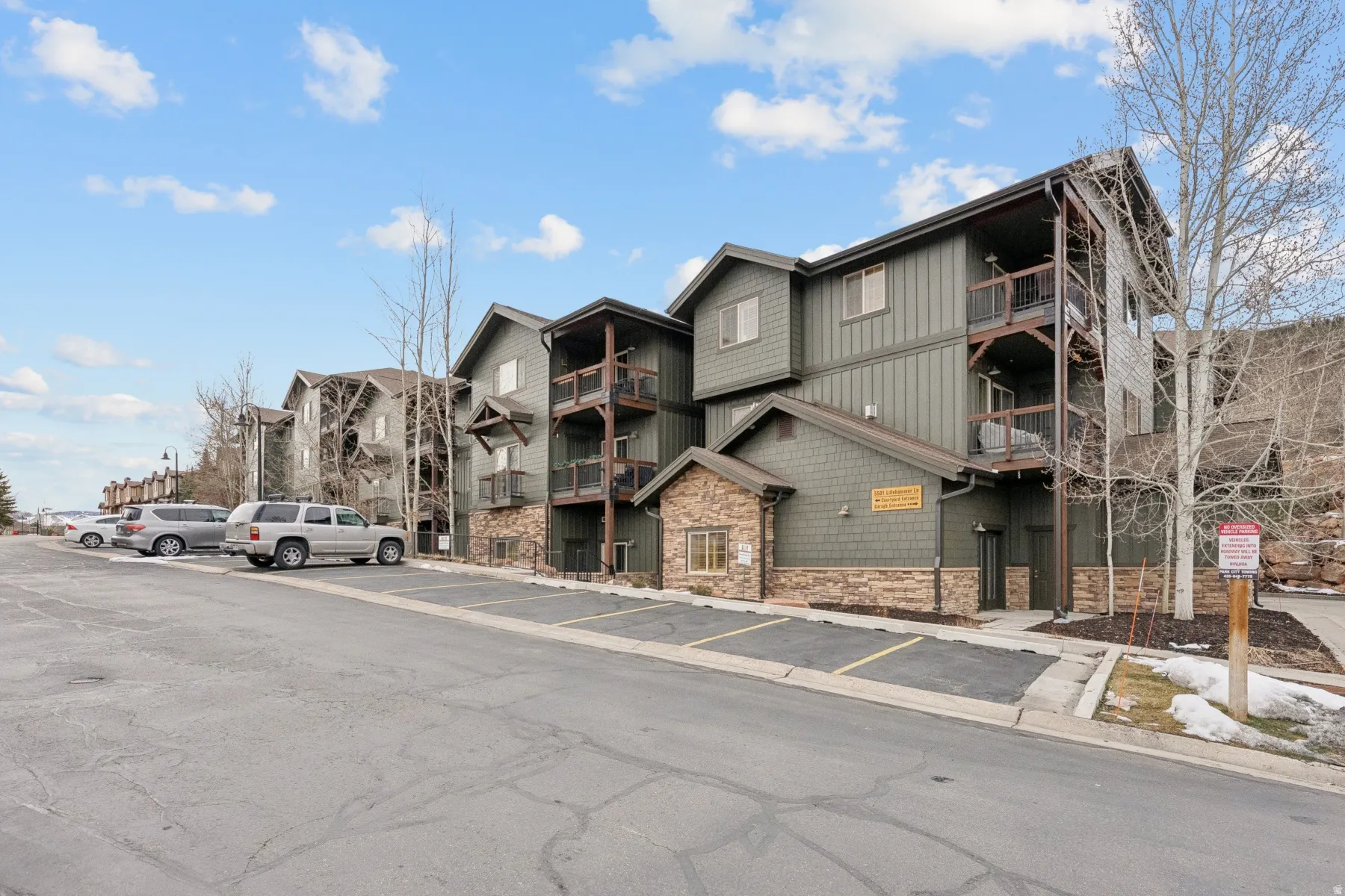 View of apartment building / complex with uncovered parking