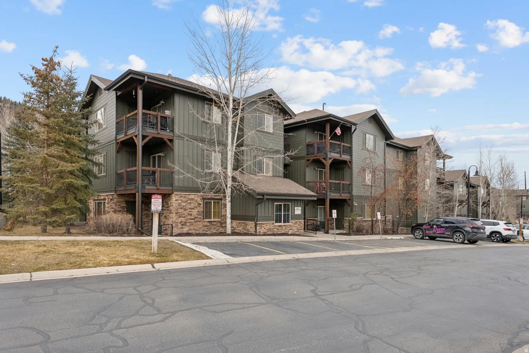 View of apartment building / complex with uncovered parking
