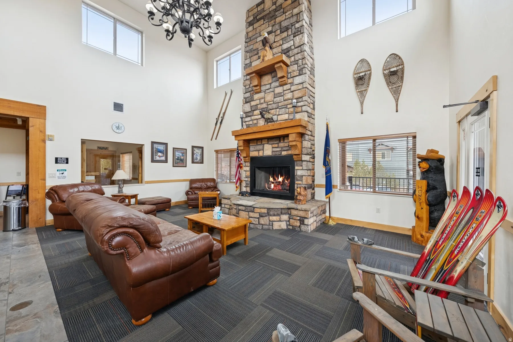 Living area with a fireplace, a high ceiling, and hanging lights