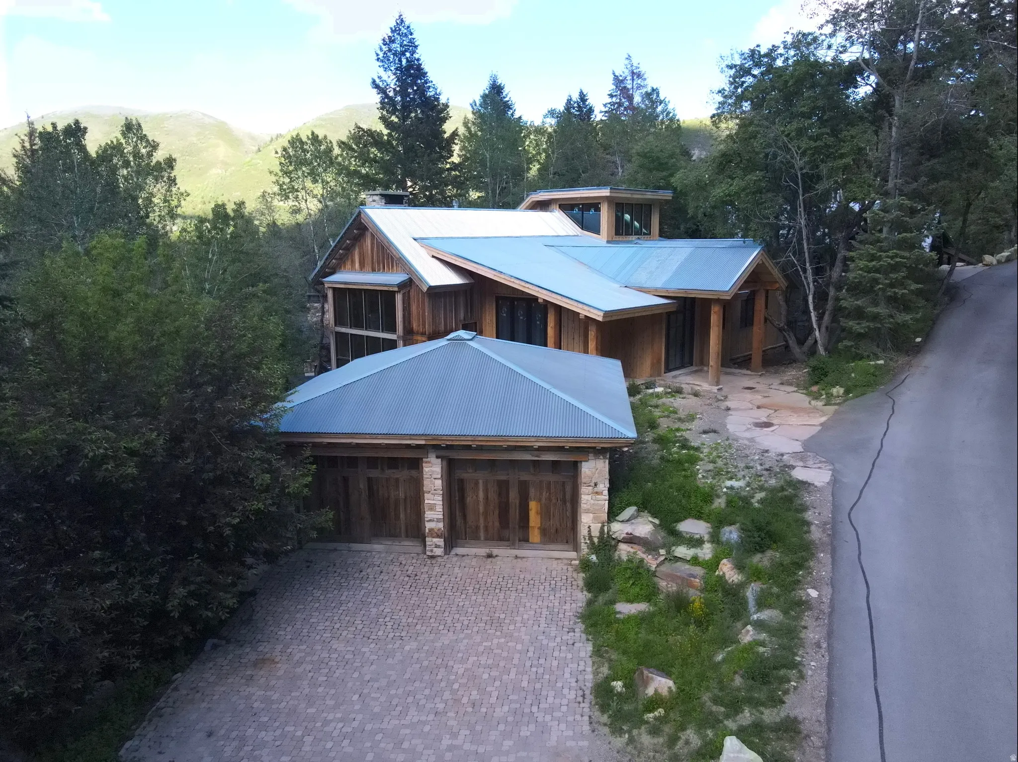 Multi-level architectural design featuring wood siding and a metal roof
