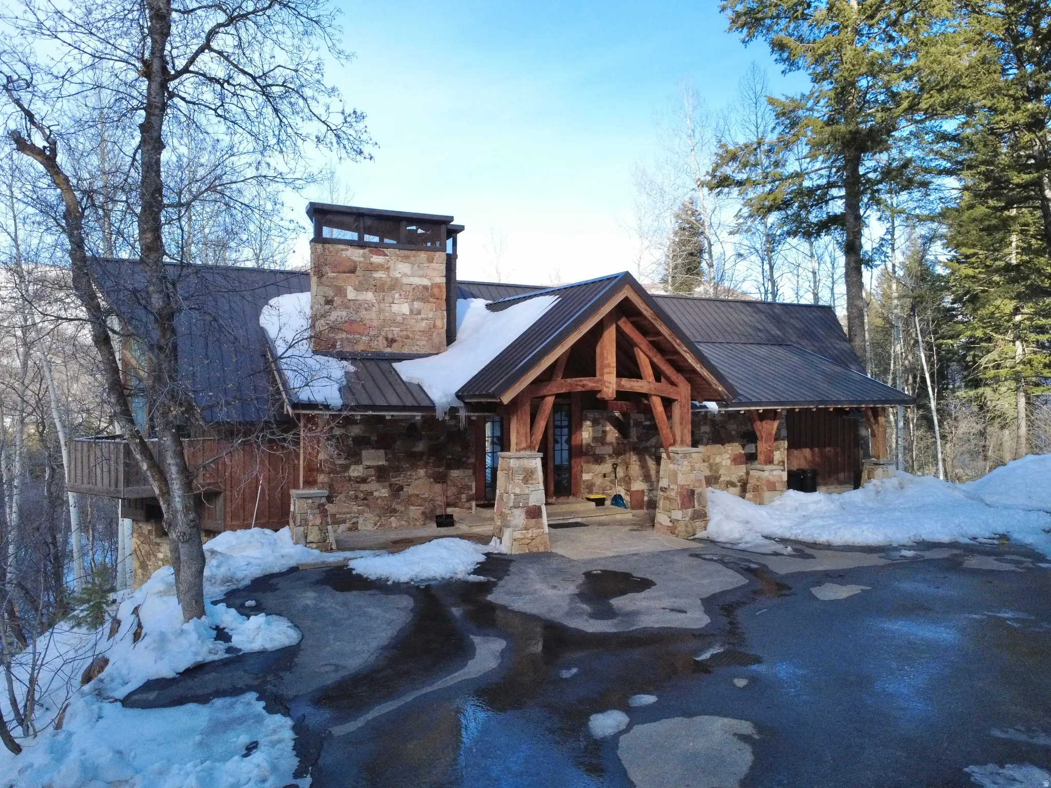 View of front of home with stone siding and a standing seam roof