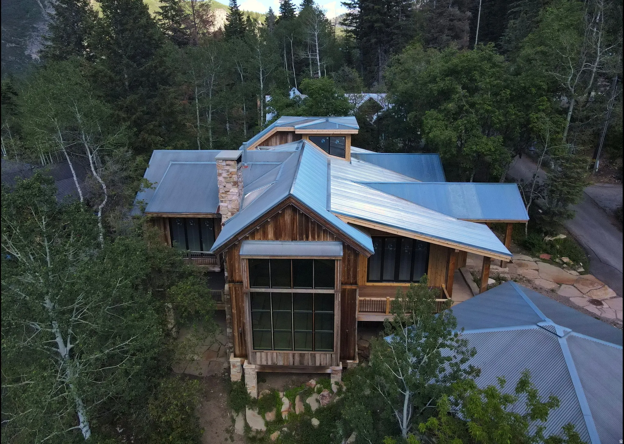 Multi-level residence featuring wood siding and a metal roof