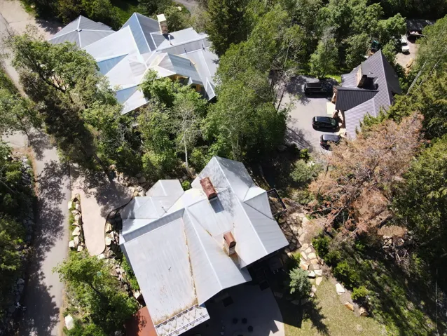 Multiple properties featuring varied rooflines, extensive surrounding greenery, and paved driveways