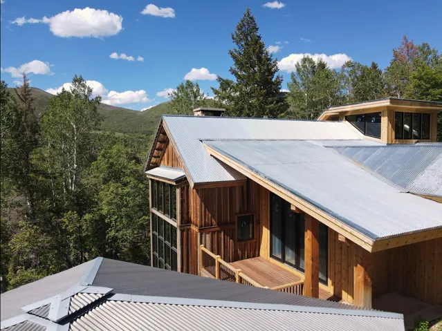 Modern architectural design featuring vertical wood siding and corrugated metal roofing