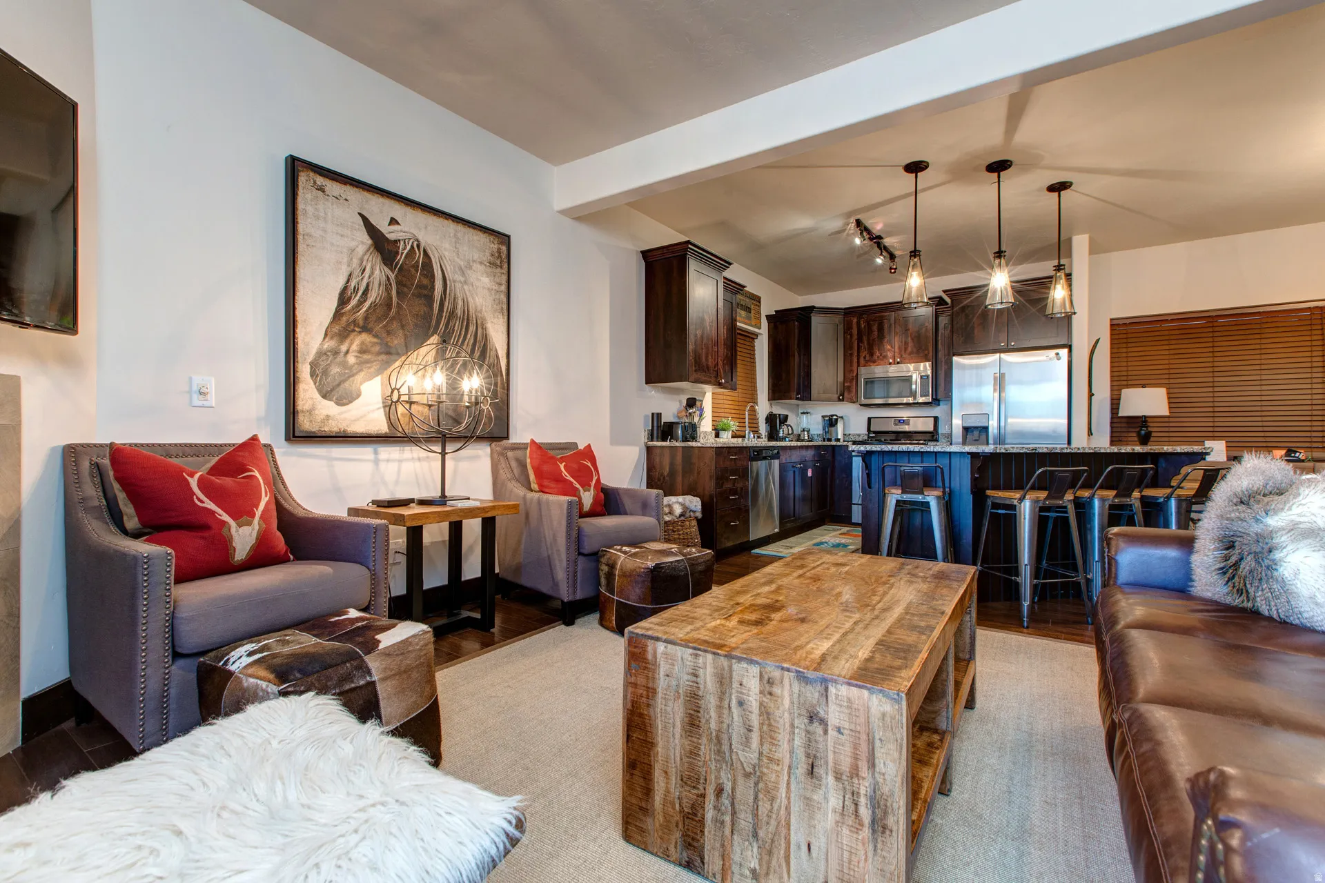 Living area with beamed ceiling, light wood finished floors, and rail lighting