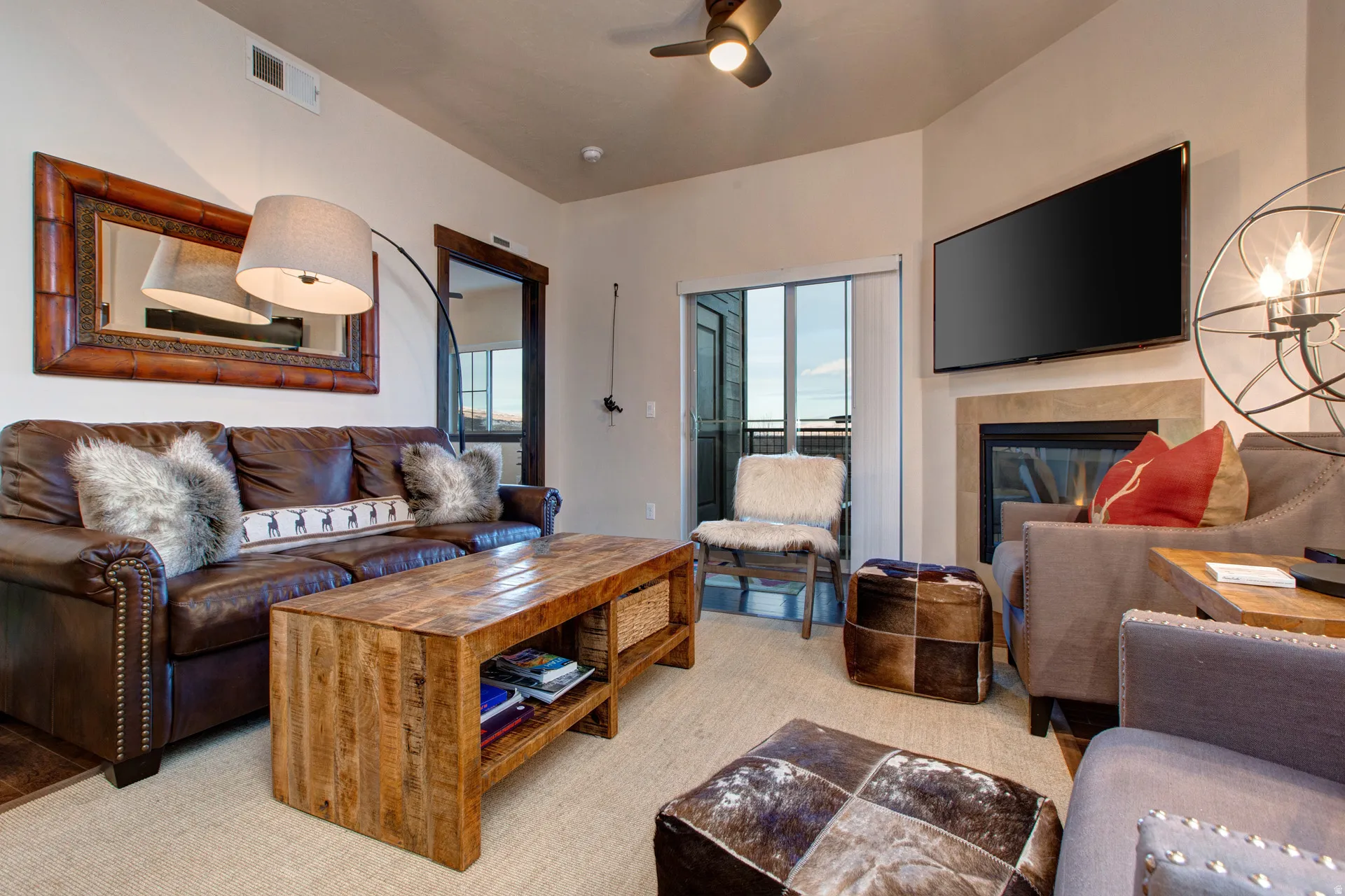 Living area with a tile fireplace and ceiling fan