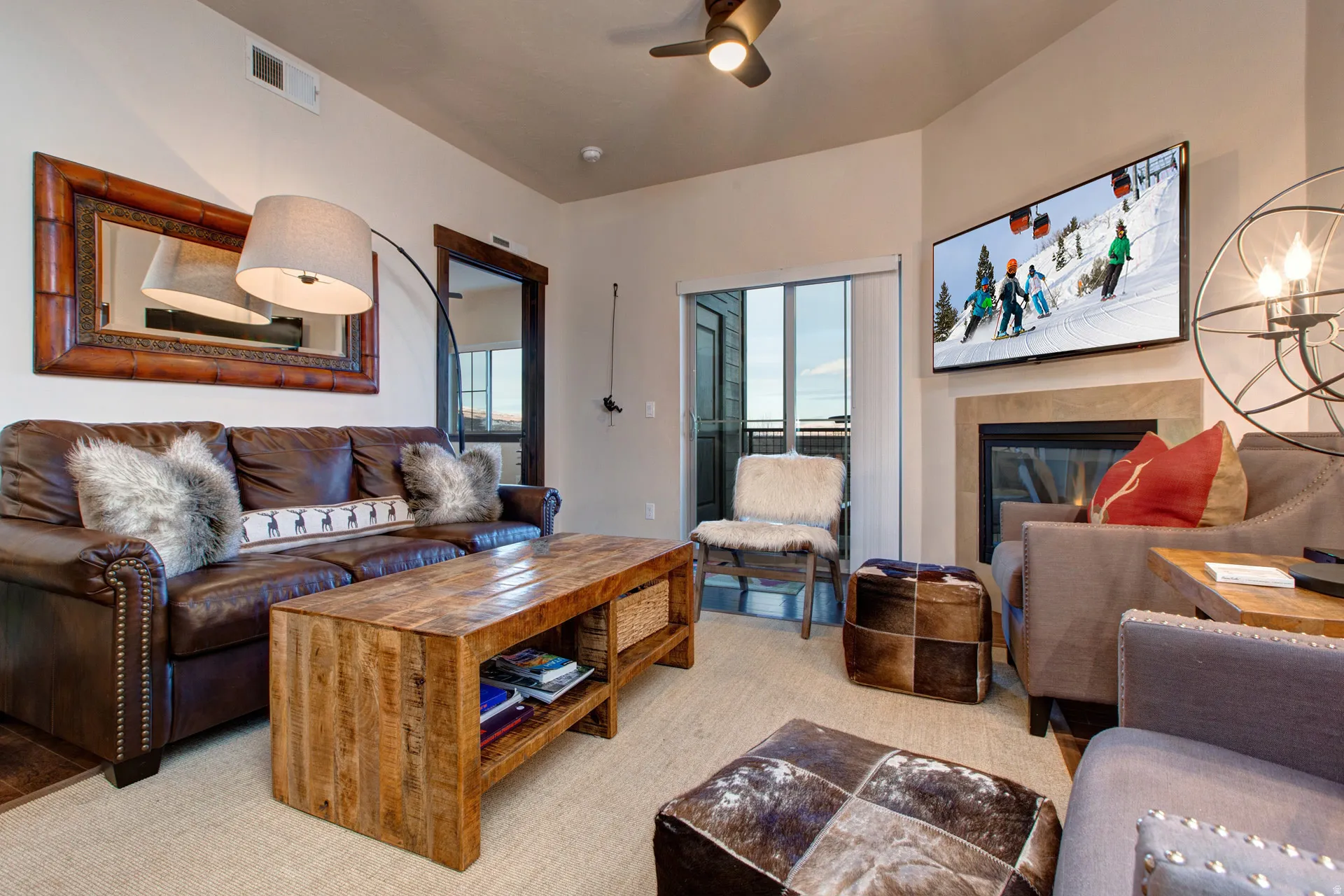 Living room featuring a tile fireplace and ceiling fan