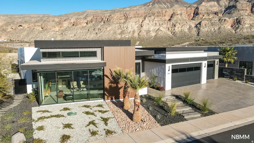 Contemporary house with driveway, a mountain view, and a garage.