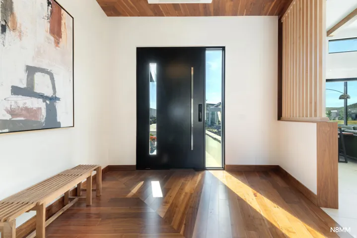 Grand entryway featuring dark wood finished floors, and healthy amount of natural light