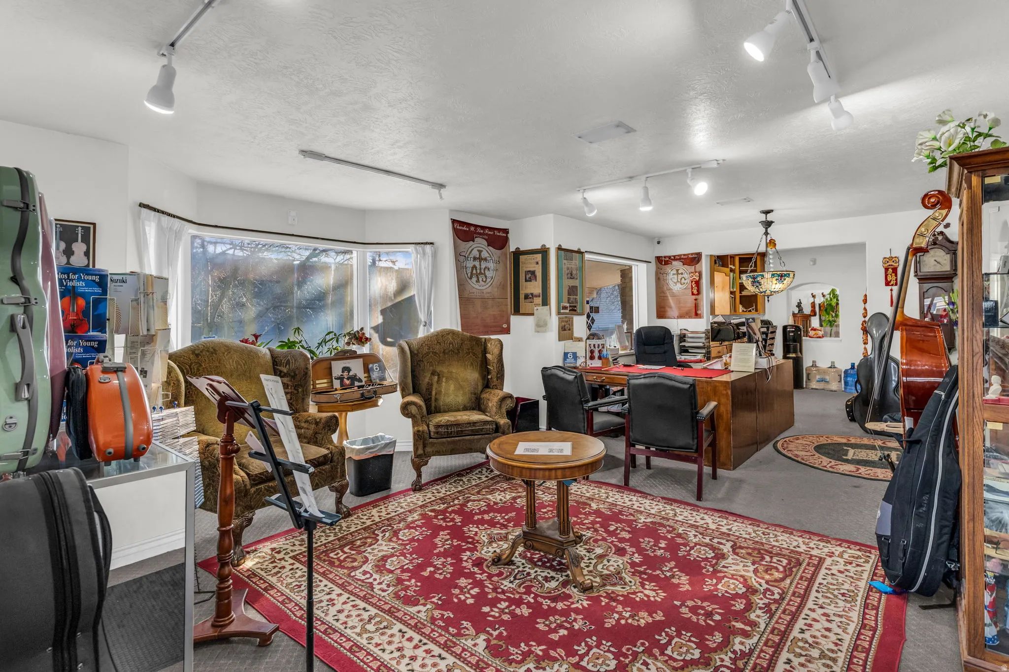 Living room with track lighting, carpet, a textured ceiling, and an office area