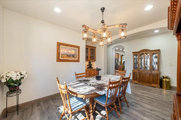 Dining room featuring arched walkways, wood finished floors, and a chandelier