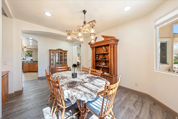 Dining space featuring arched walkways, dark wood finished floors, and recessed lighting