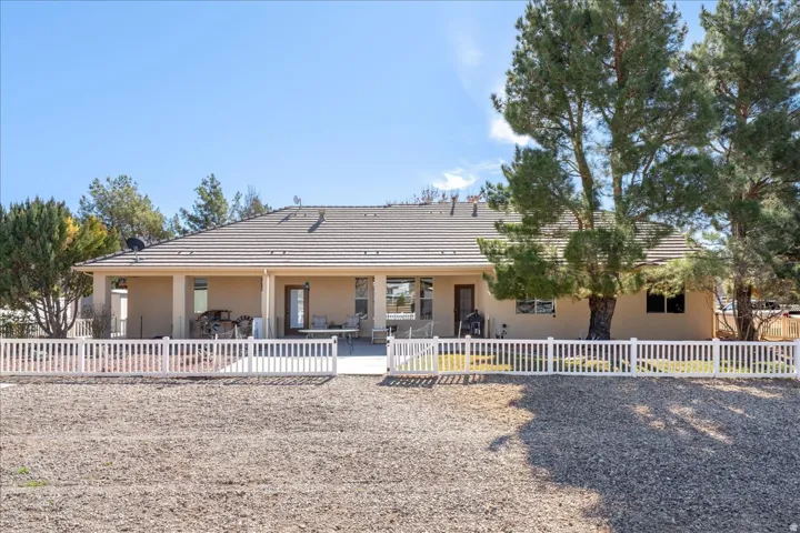 View of front of house with stucco siding, a patio, and a tile roof