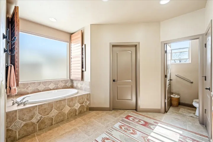 Bathroom featuring a bath, recessed lighting, and light tile patterned floors