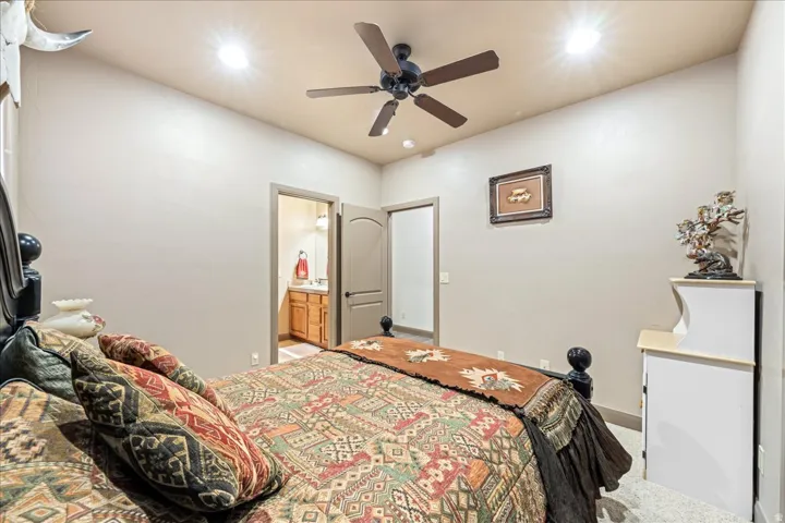 Bedroom with recessed lighting, ensuite bathroom, a ceiling fan, and carpet