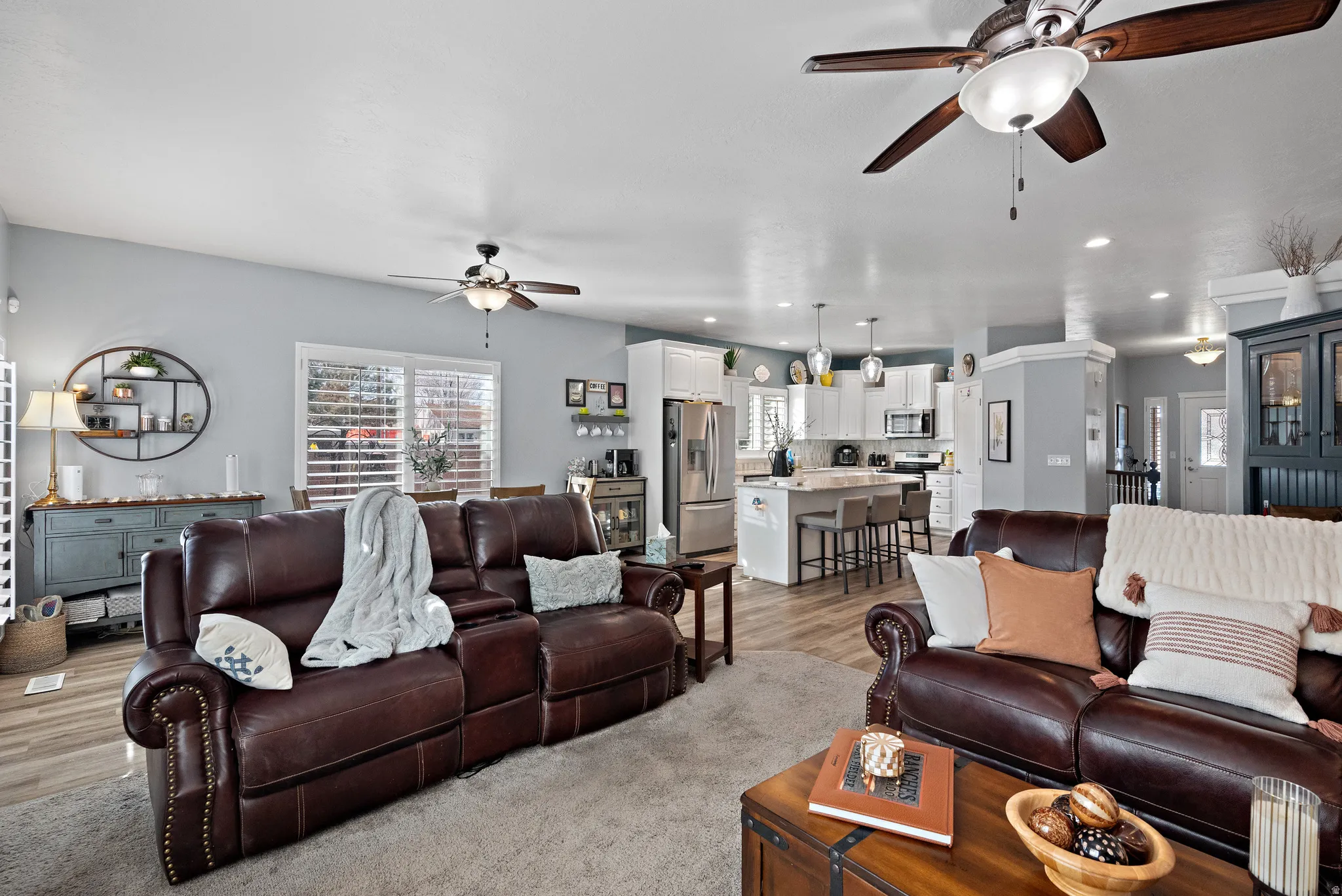 Living area with a ceiling fan, light wood finished floors, and recessed lighting