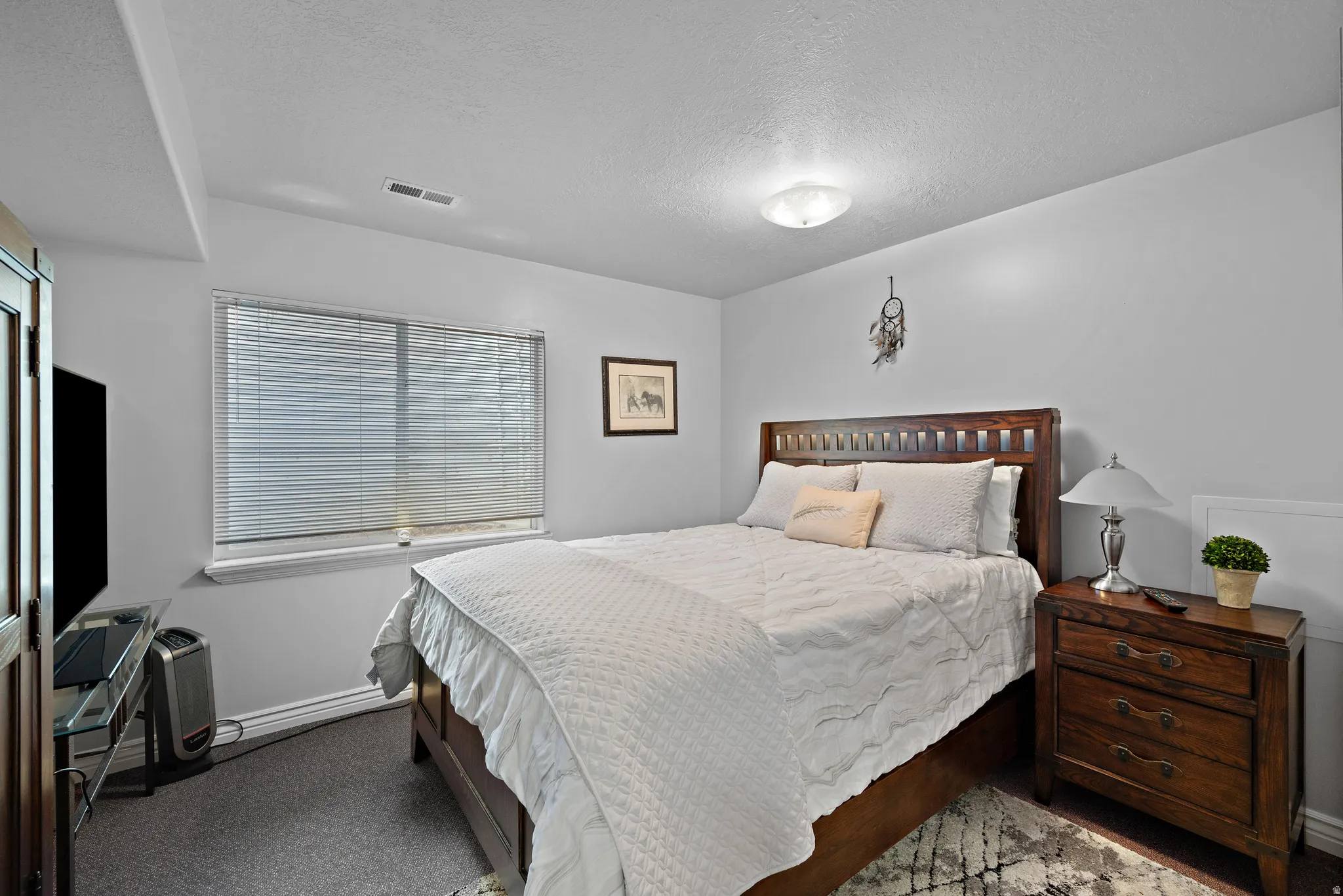 Carpeted bedroom featuring baseboards and a textured ceiling