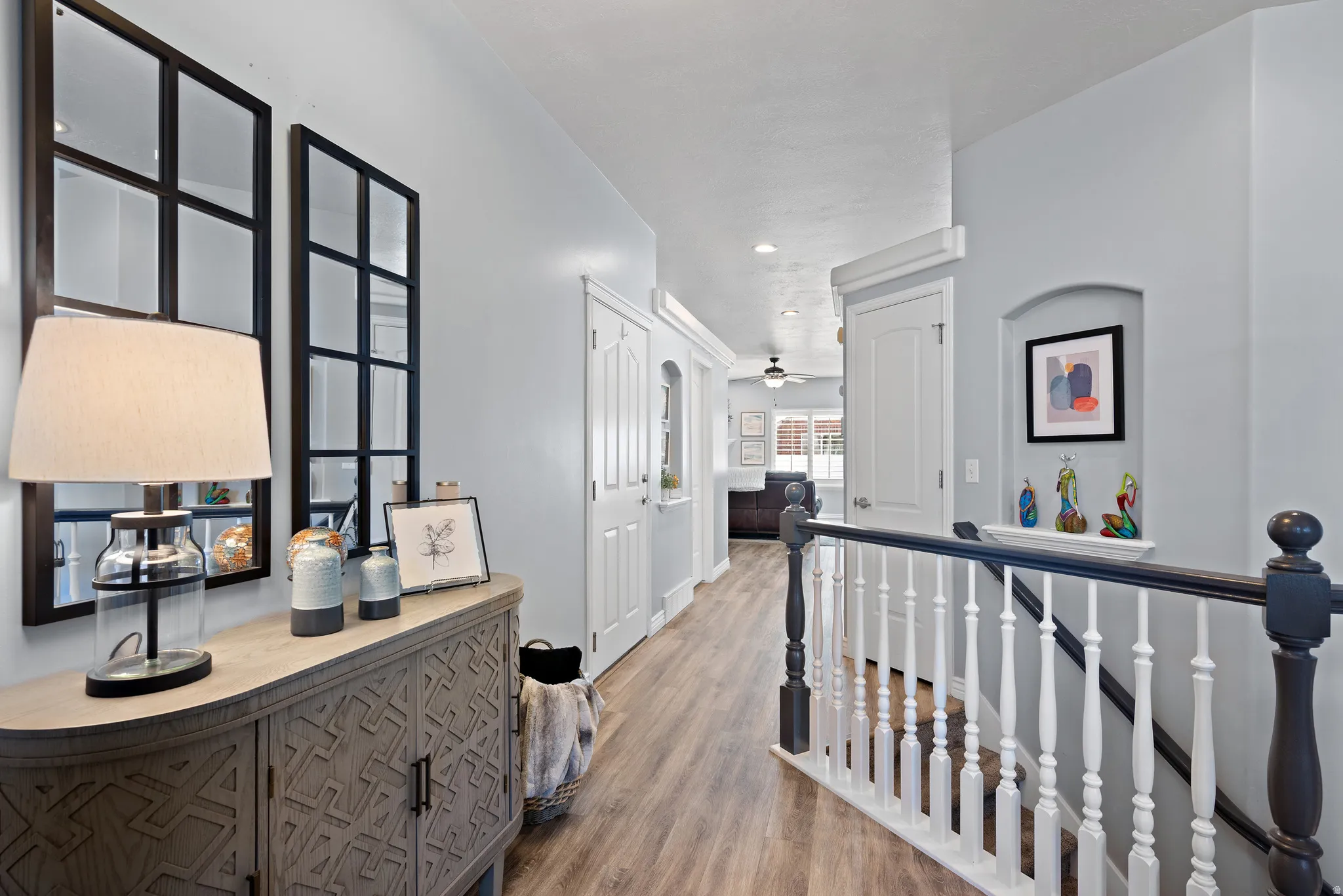 Hallway featuring an upstairs landing, light wood-style floors, and recessed lighting