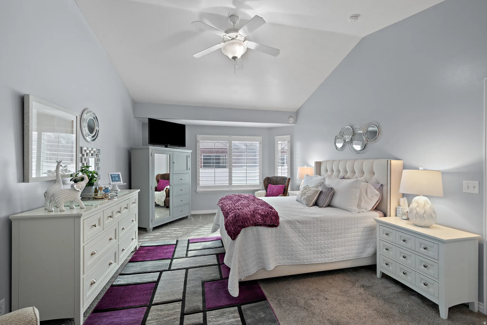 Bedroom with vaulted ceiling, dark carpet, and ceiling fan