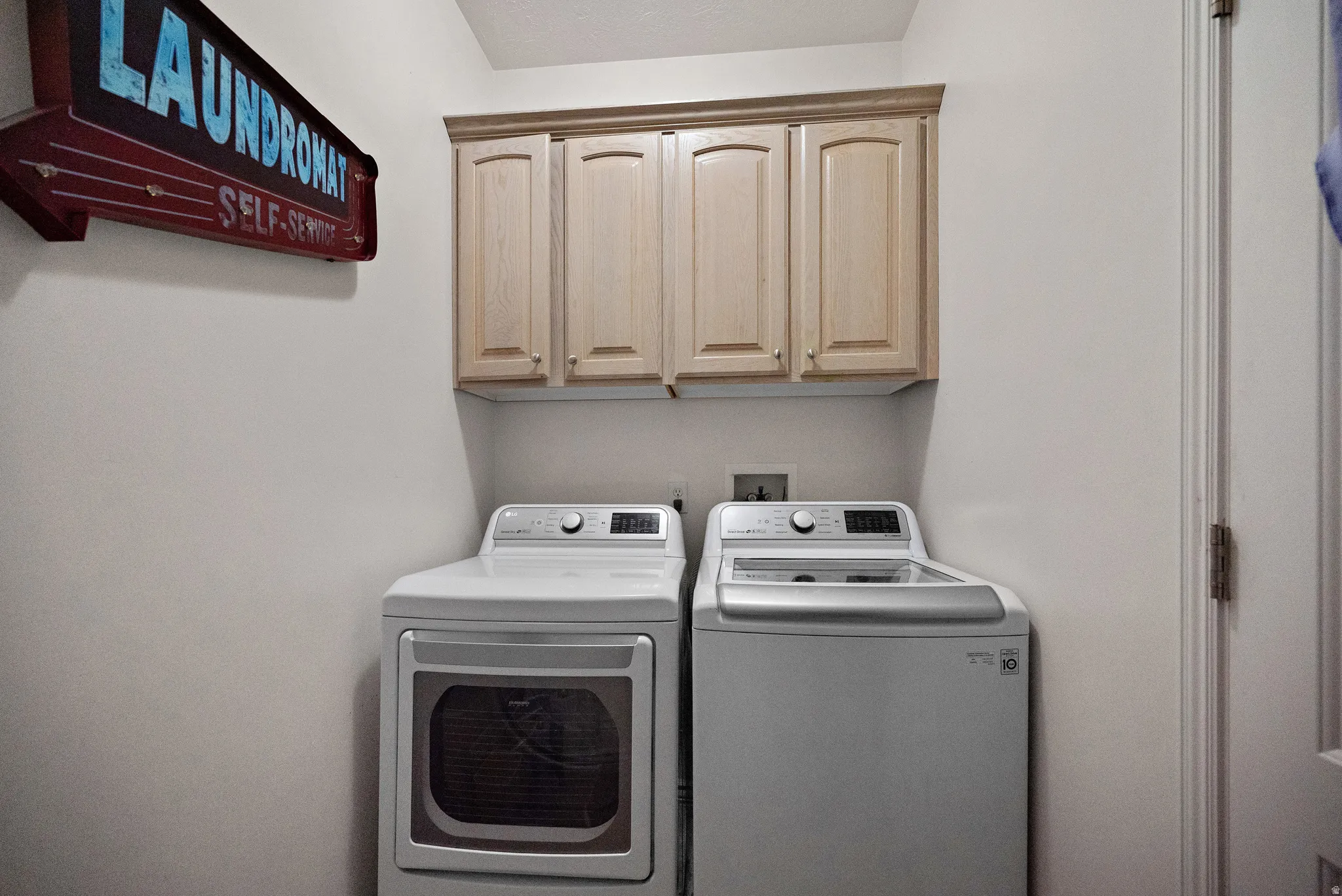 Laundry area featuring washer and clothes dryer and cabinet space
