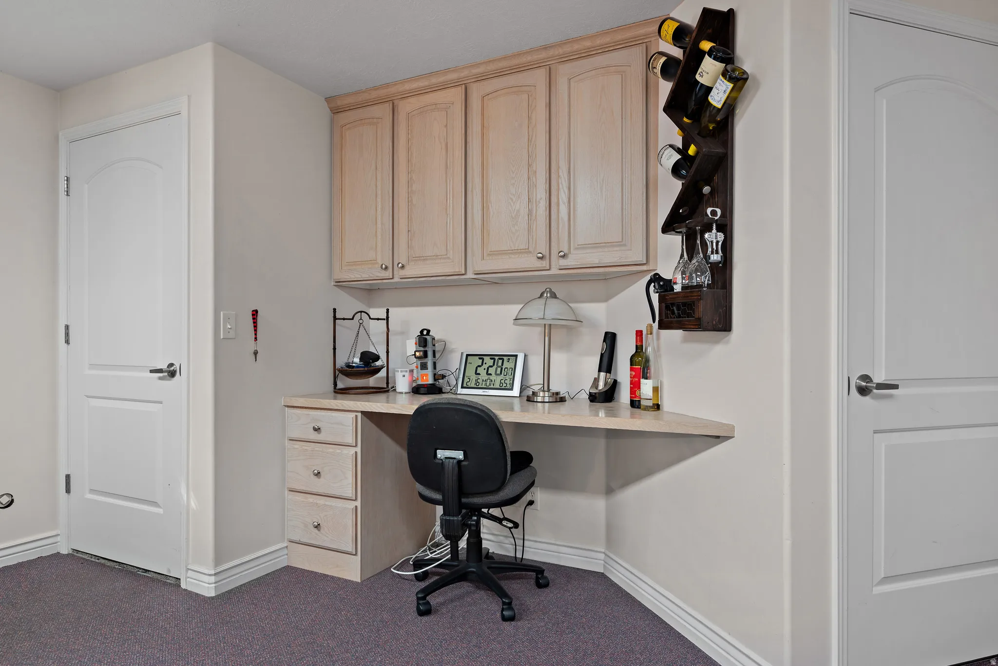Office area featuring built in desk and dark carpet