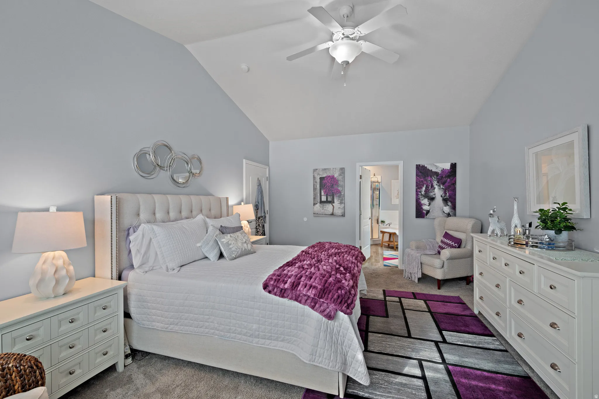 Bedroom with carpet, vaulted ceiling, a ceiling fan, and ensuite bath