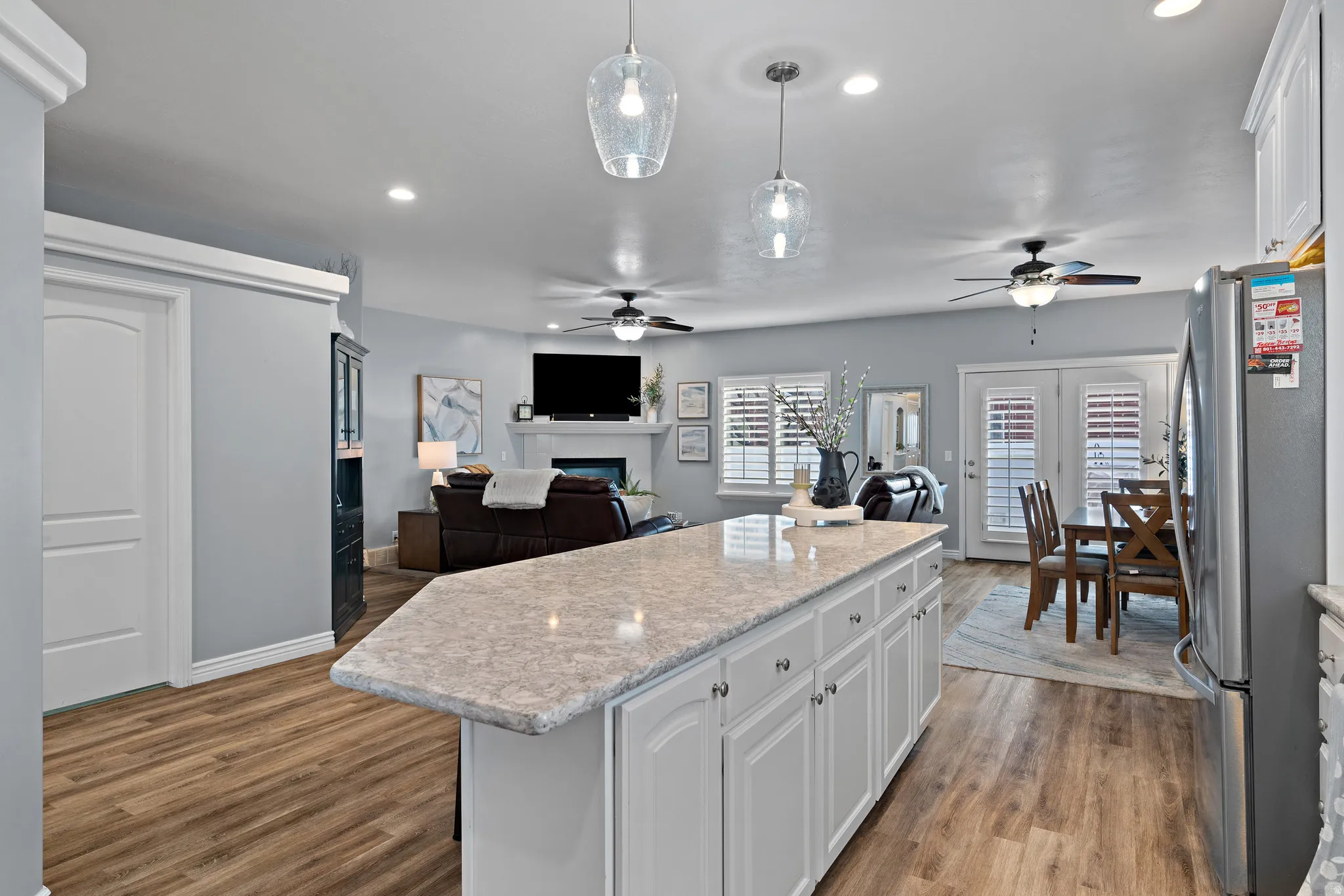 Kitchen with a ceiling fan, white cabinetry, open floor plan, and a kitchen island