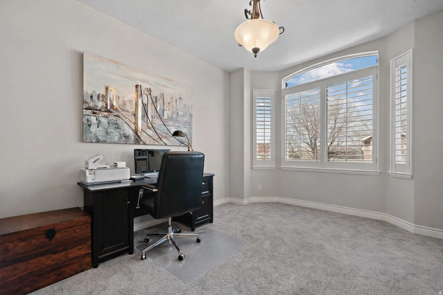 Home office with light colored carpet and baseboards