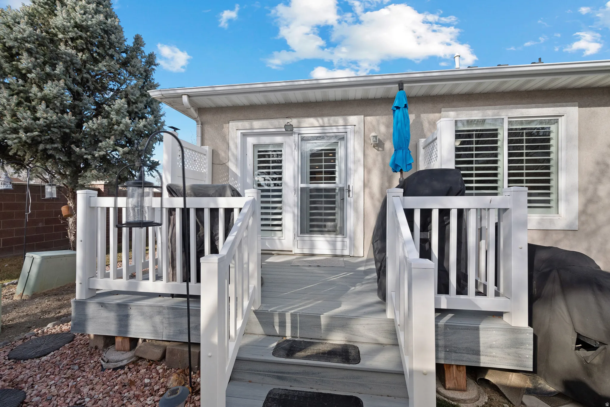 View of exterior entry featuring a deck and stucco siding