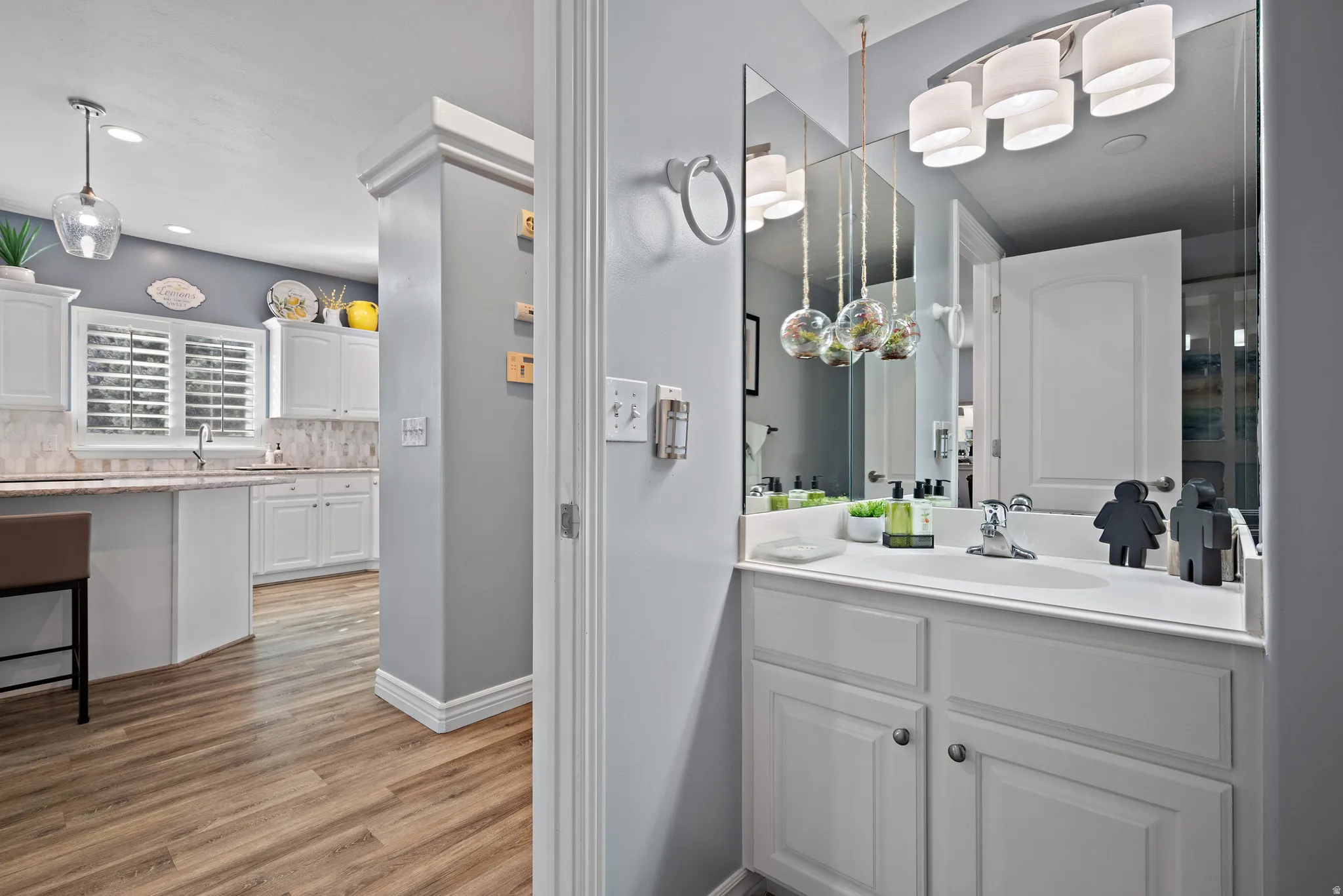 Full bath with vanity, decorative backsplash, light wood-style floors, and recessed lighting