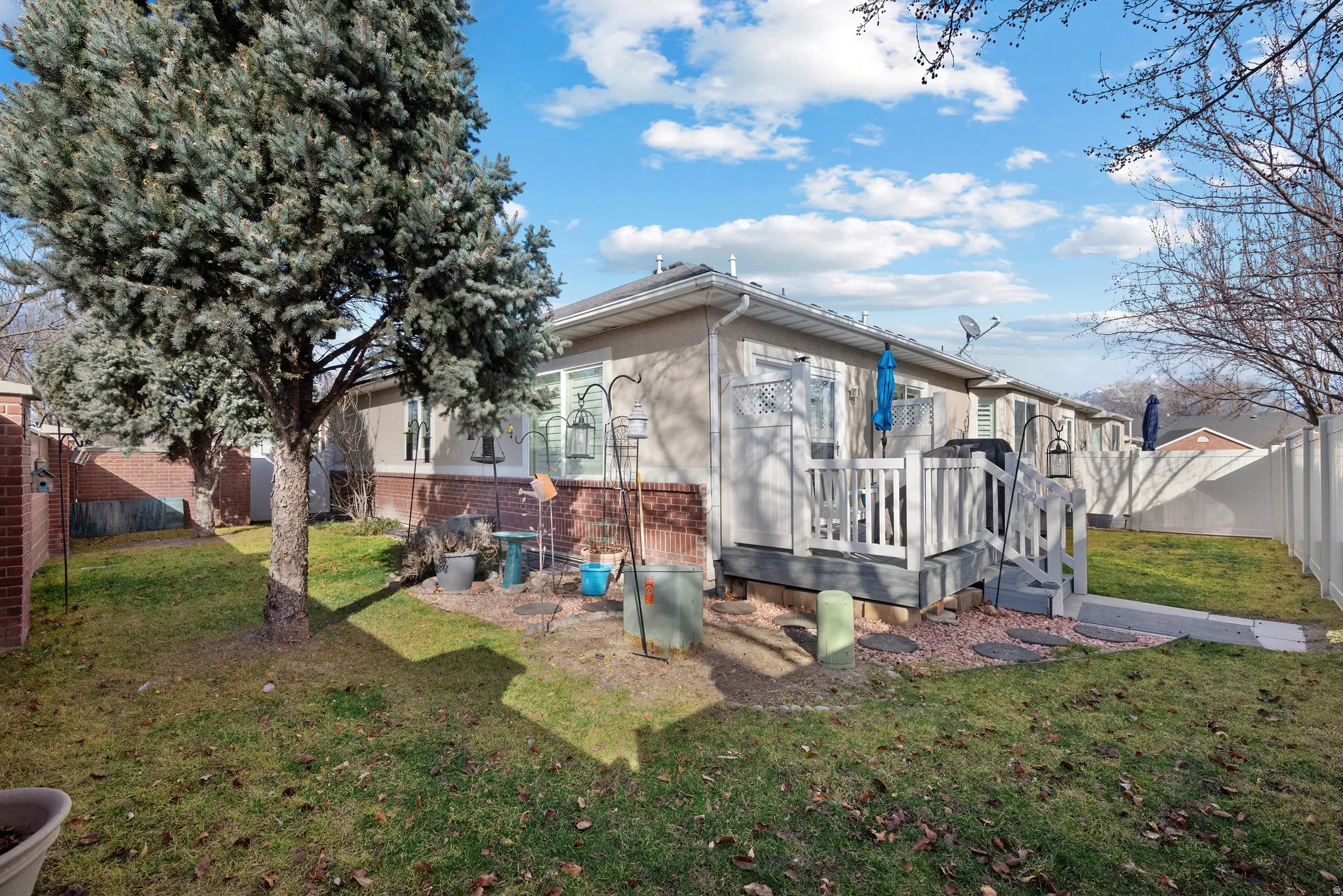 Back of property featuring a deck and brick siding