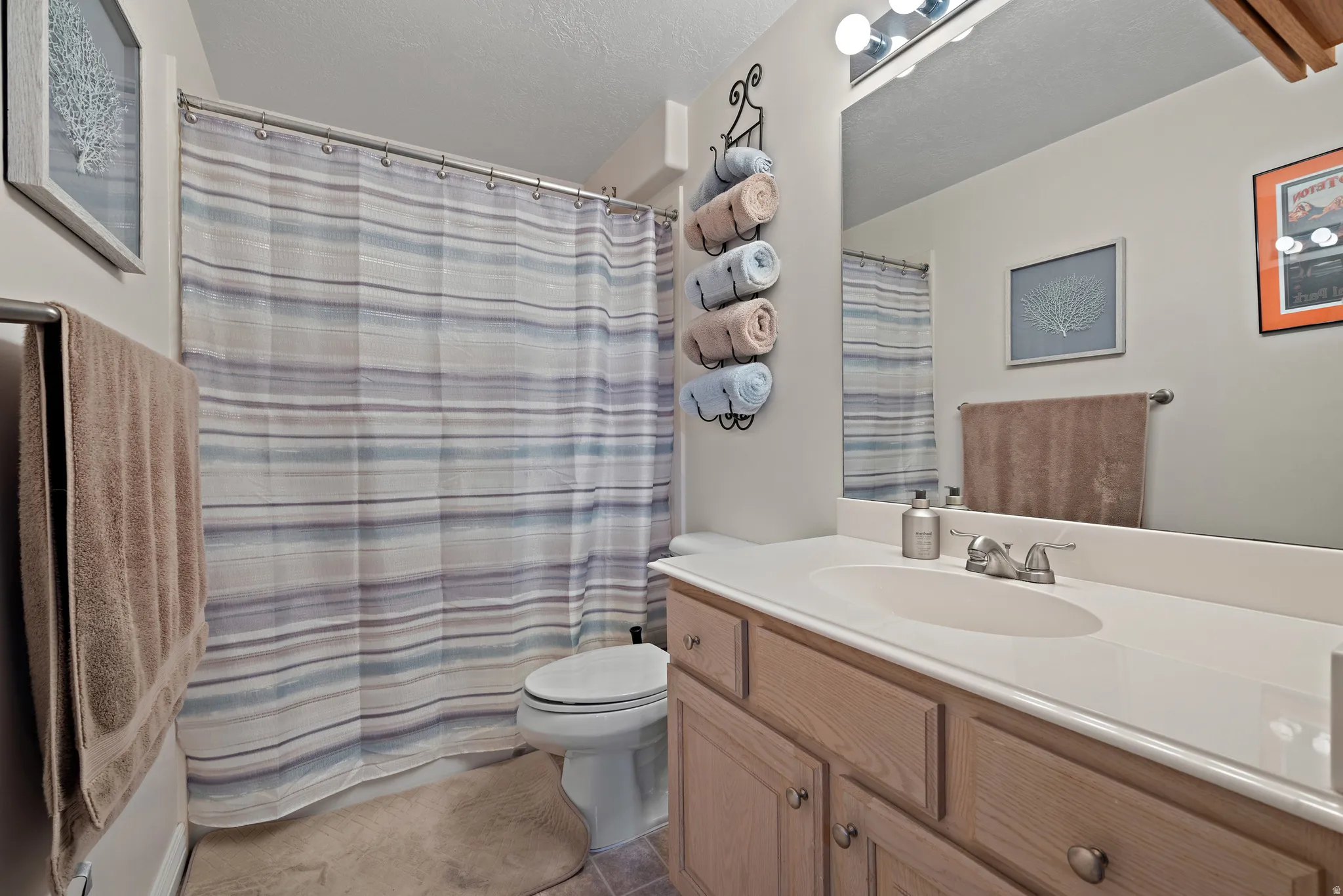 Full bath featuring vanity, a shower with curtain, and light tile patterned floors