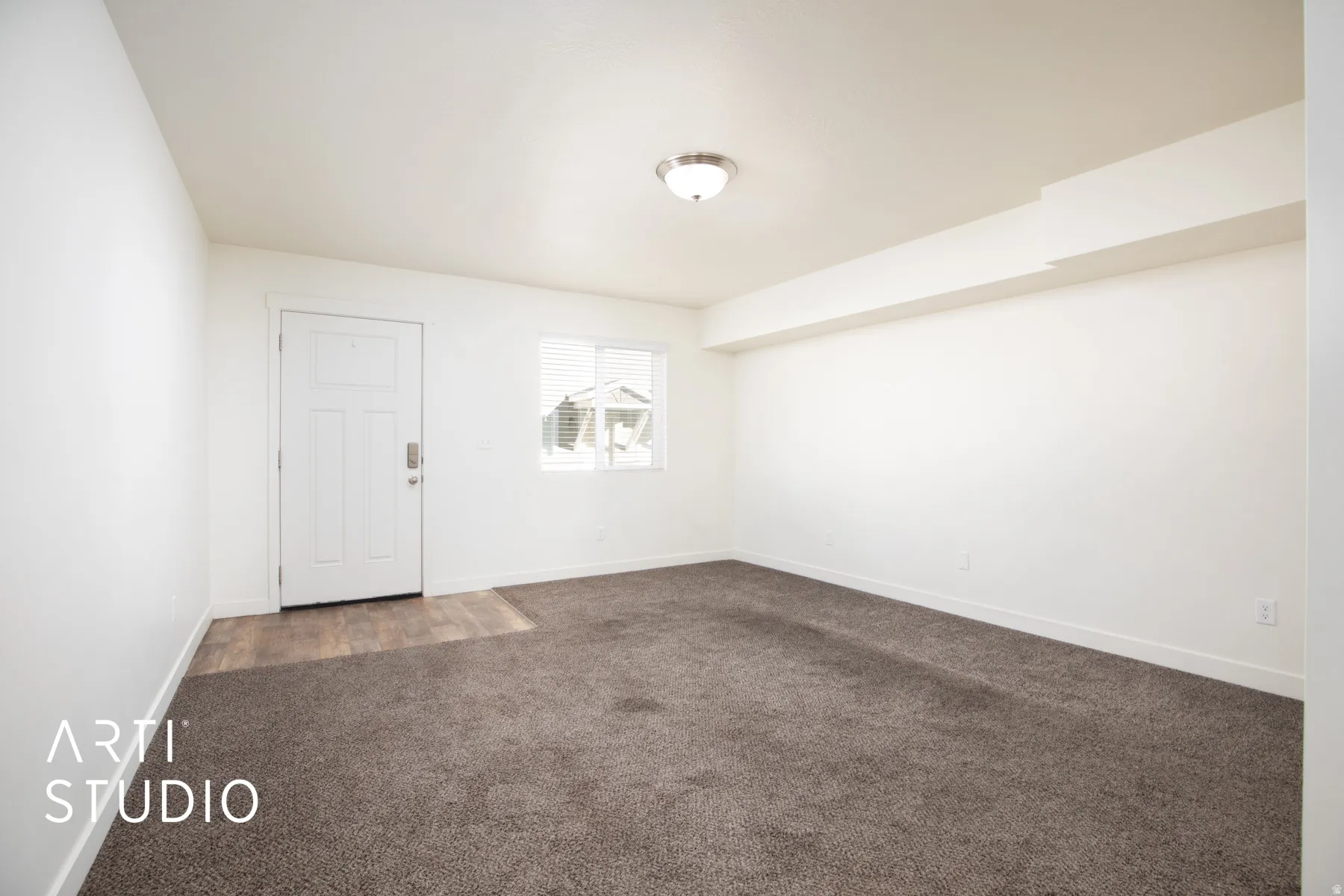 Carpeted empty room featuring baseboards